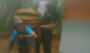 Wabup Gagarin saat membantu menjinjing tampah milik nenek renta di Desa Watupatok.