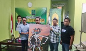 Koordinator pegiat Desa Septian Dwi Cahyo serahkan cinderamata lukisan Hanoman.