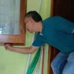 Muhajir saat menunjukkan jendela rumahnya yang di congkel maling kala itu. (doc).