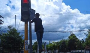 Teknisi dari Dishub Pacitan, saat melakukan perbaikan bolam lampu Apiil di persimpangan Alijah.